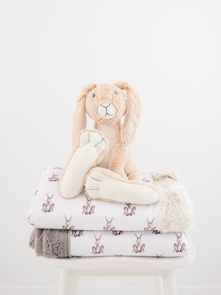 Bunny sitting on stack of blankets