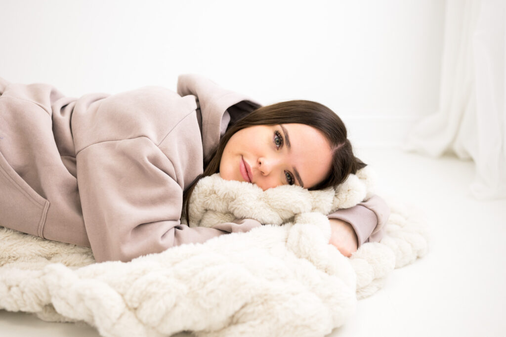 Woman dressed in Comfrt resting on Minky blanket